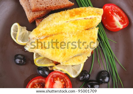 served roast golden fish fillet with tomatoes, rye bread and olives