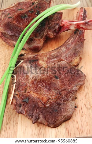 served main course: grilled pork ribs served with green chives over wooden plate