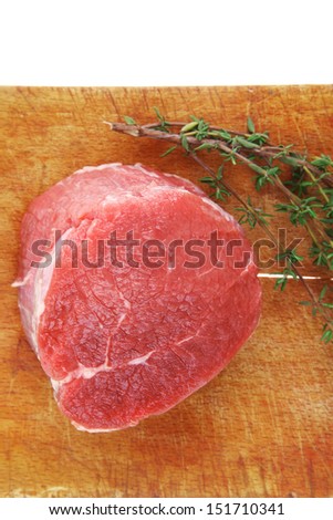 red raw fillet chops : fresh beef meat with thyme on wooden plate . isolated over white background