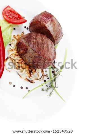 grilled beef fillet with thyme , red hot chili pepper and tomato on plate isolated over white background