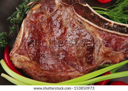 meat food : grilled beef spare rib on dark dish with thyme pepper and tomato isolated over white background