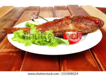 main course : roasted sea fish on plate with tomatoes, lemon and spices