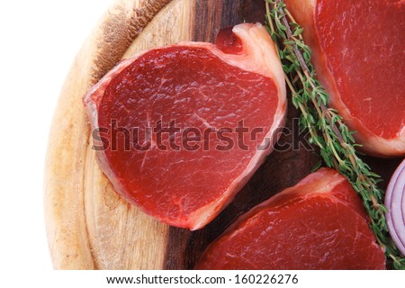 uncooked raw beef fillet with thyme twig on wooden plate isolated over white background low fat