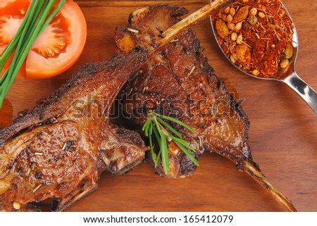 savory plate on wood : grilled ribs on plate with chives and tomato isolated on white background