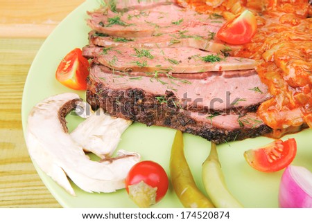 corned beef on plate with vegetables over wooden table