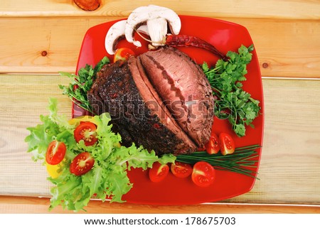 hot beef on red plate over wood table