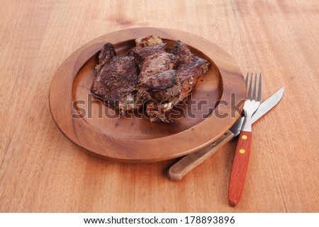 fresh roast beef barbecue on wood with cutlery over table bbq