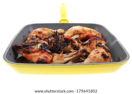 grilled chicken legs with tomatoes and thyme cooked on yellow ceramic pan isolated on white background