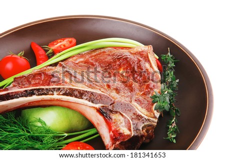 savory : roasted beef spare rib on dark dish with cutlery thyme pepper and tomato isolated over white background