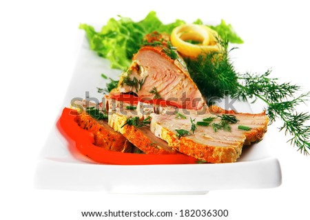 healthy dinner: grilled sea tuna fish with lemon and vegetables on white china plate isolated over white background