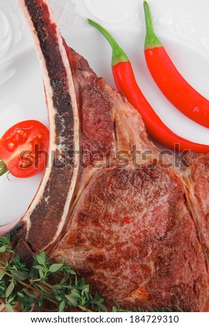 savory : roasted beef spare rib on white dish with cutlery thyme pepper and tomato isolated over white background