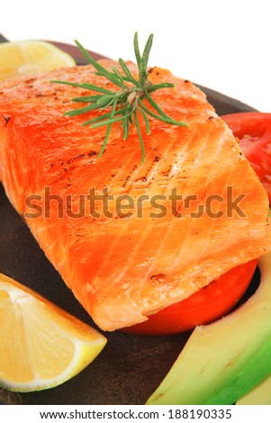 healthy lunch : sea roast salmon on metal pan over red wooden plate with vegetables isolated over white background