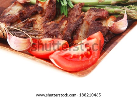 hot lunch of fresh beef meat roasted ribs with asparagus and tomatoes isolated over white background