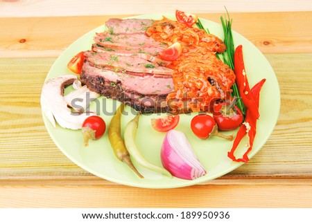 corned beef on plate with vegetables over wooden table