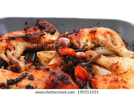 grilled chicken legs with tomatoes and thyme cooked on yellow ceramic pan isolated on white background