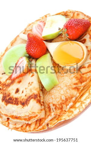 dessert : thin round pancake with honey strawberries and apple isolated over white background