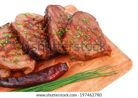 fresh ripe roasted beef meat on wooden plate with thyme and chives isolated on white background