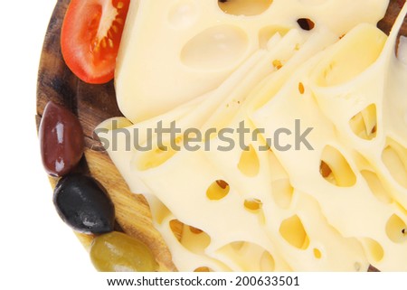 gold edam cheese sliced on wooden platter with olives and tomato isolated over white background