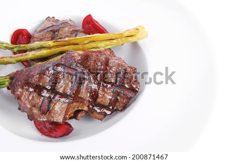 grilled red beef pork meat barbecue steak fillet with asparagus and hot pepper served on deep plate isolated on white background
