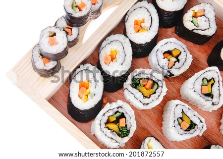 Maki Rolls and California rolls made of fresh raw Salmon, Tuna and Eel with Cream Cheese and Avocado . Isolated over white background . on wooden plate with live crab . Maki Sushi and Nigiri