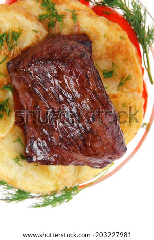 fresh roast beef meat chunk in transparent bowl over baked potatoes and tomatoes served with fill isolated over white background