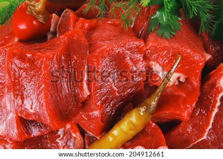 raw fresh beef meat slices in a ceramic dish with onion and red peppers isolated over white background