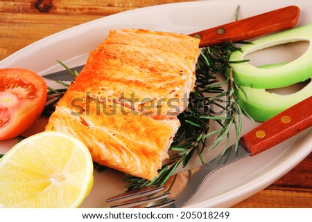 roast fish: hot grilled salmon over glass plate on over wooden table