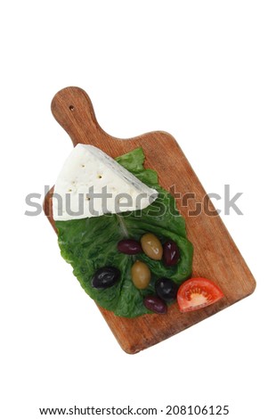 stilton cheese on wooden platter with olives and tomato isolated over white background