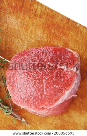 red raw fillet chops : fresh beef meat with thyme on wooden plate . isolated over white background