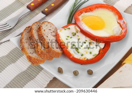 fried eggs and tortilla with salad served on white plate with cutlery over tablecloth in restaurant