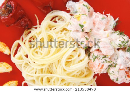 fresh rose wild salmon baked in cream cheese sauce with italian pasta and red hot pepper on square plate isolated over white background