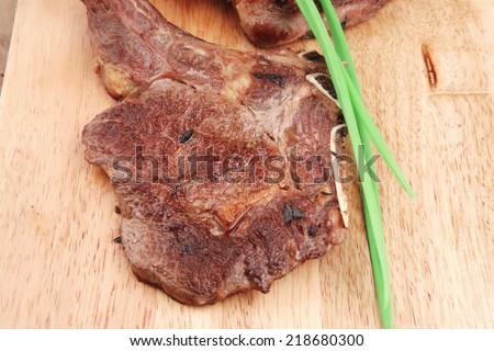 meat savory : roasted beef ribs served with green chives over black table