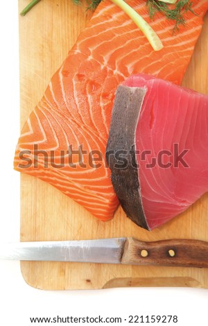 uncooked fresh salmon and red tuna fish pieces served over wooden board isolated on white background