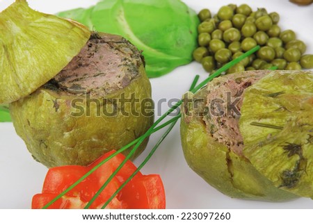 meat meal: round zucchini filled mince meat over white dish served with vegetables