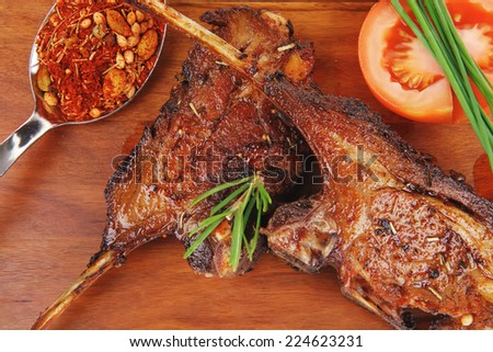 savory plate on wood : grilled ribs on plate with chives and tomato isolated on white background
