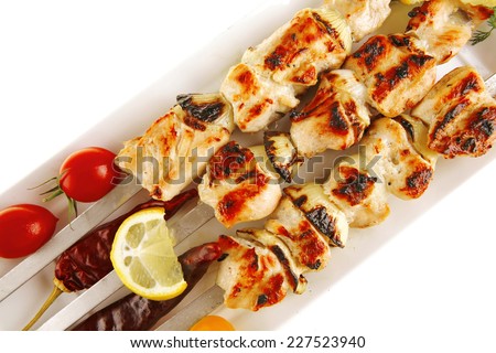 shish kebab on white platter with vegetables