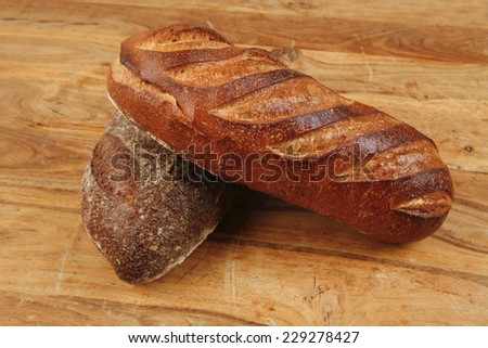 different rye and white flour french bread loaf with on light wooden table background high resolution