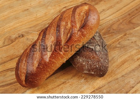 different rye and white flour french bread loaf with on light wooden table background high resolution