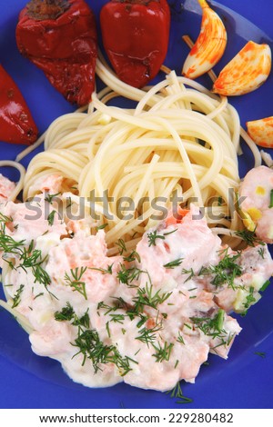 fresh rose wild salmon baked in cream cheese sauce with italian pasta and red hot pepper on blue plate isolated over white background high resolution hidef