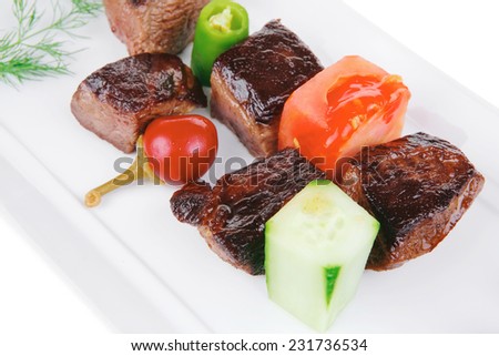european food: roast beef meat goulash over white plate isolated on white background with tomatoes and dill