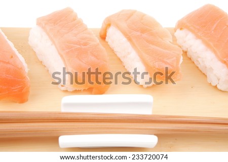 Nigiri Sushi - Set of Nigiri sushi topped with raw Salmon . isolated over white background . on wooden board