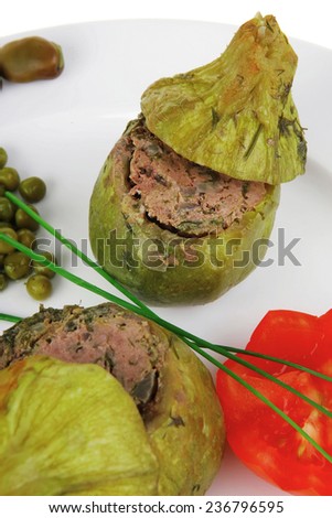 meat meal: round zucchini filled mince meat over white dish served with vegetables