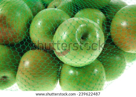 fresh green apples in green transport net ready to sell isolated on white background