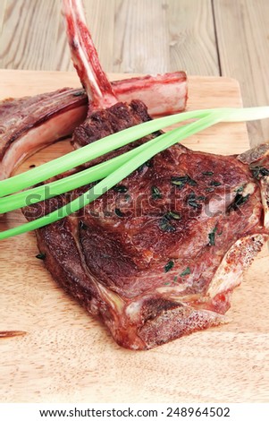 meat savory : grilled beef ribs served with green chives on wooden table