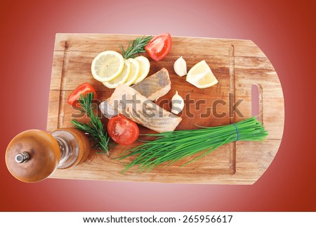 healthy fish cuisine : baked pink salmon steaks with green onion, cherry tomatoes, small pepper grinder, rosemary twigs and lemon on wooden board isolated on white background