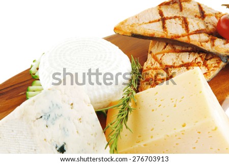 grilled sea fish salmon with french edam gorgonzola and soft feta goat cheeses on wooden plate isolated over white background