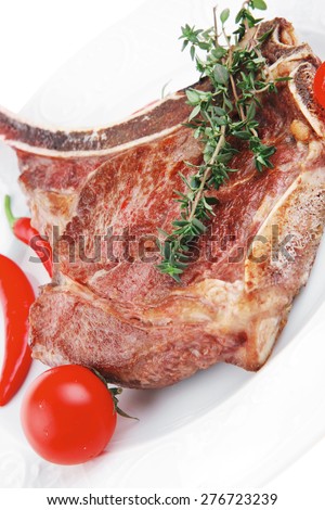 meat food : grilled beef spare rib on white dish with thyme pepper and tomato isolated over white background
