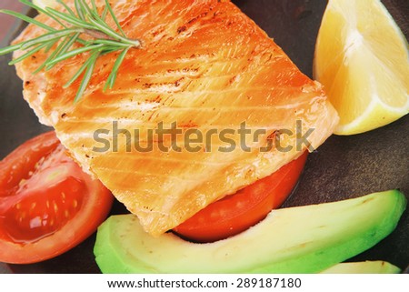 healthy lunch : sea roast salmon on metal pan over red wooden plate with vegetables isolated over white background