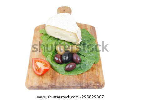 aged camembert cheese on wooden platter with olives and tomato isolated over white background