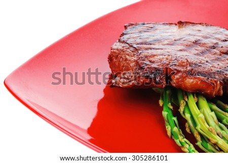 meat table : rare medium roast beef fillet asparagus served on red dish isolated over white